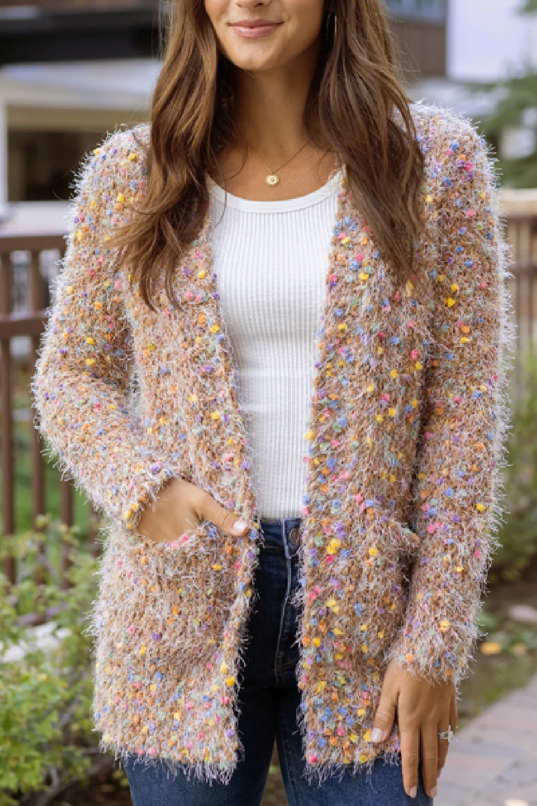 Woman wearing a colorful textured cardigan outdoors