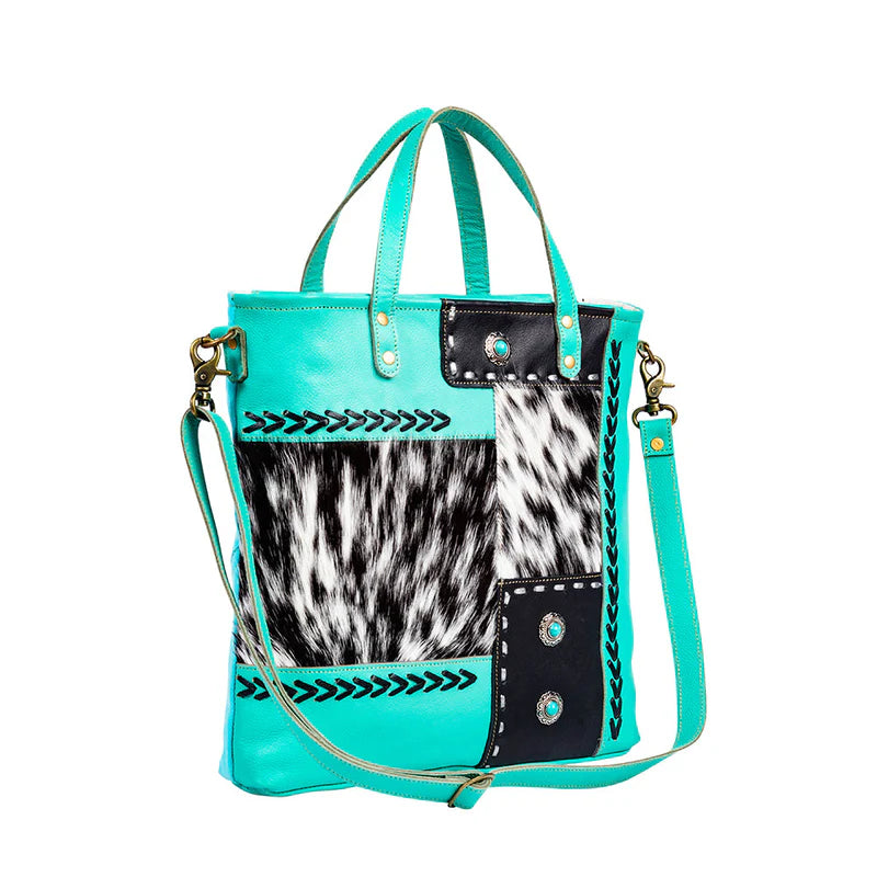 Myra turquoise handbag with cowhide pattern and decorative elements. 